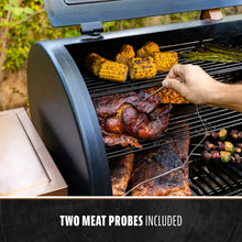 Black electric grill with two meat probes included, cooking corn, beans, and meat.