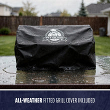 Black Pit Boss all-weather fitted grill cover, water-resistant, shown in rain on a grill. Logo visible on front.