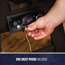 Digital grill control panel with a hand plugging in a meat probe; display shows 99°F. One meat probe included.