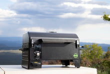 Compact black tabletop pellet grill with digital control panel, sturdy handle, and side vents. Ideal for outdoor cooking.