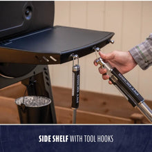 Grill side shelf with tool hooks, black metal design.