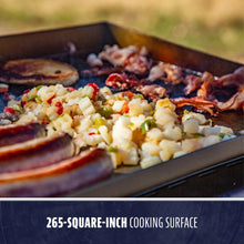 Close-up of a 265-square-inch flat top griddle cooking breakfast foods like sausage, potatoes, and bacon.