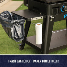 Outdoor grill accessory with a trash bag holder and paper towel holder attached for easy cleanup and convenience.