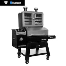 Large black and silver pellet grill with dual-door smoker cabinet, Bluetooth/WiFi enabled, on wheels for easy mobility.