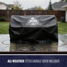 Black Pit Boss all-weather fitted griddle cover, water-resistant, shown outdoors in the rain.