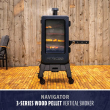 Black vertical wood pellet smoker with glass door, shelves, and wheels. "Pit Boss" logo on front. ADA-optimised.