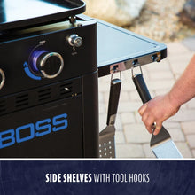Outdoor grill with a side shelf and built-in tool hooks, black finish, easy-access knobs, ADA-optimized design.
