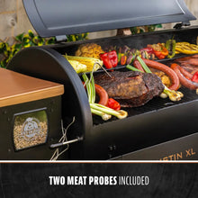 Black Pit Boss grill with lid open, cooking meats and vegetables, two meat probes included.