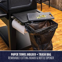 "Black outdoor kitchen station with paper towel holder, trash bag, cutting board, and bottle opener."