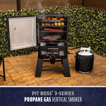 Black Pit Boss 3-Series Propane Gas Vertical Smoker with food cooking inside.