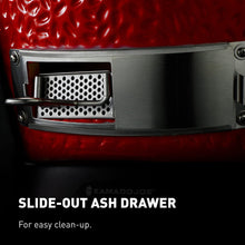 Slide-out ash drawer on a Kamado Joe grill with red ceramic surface