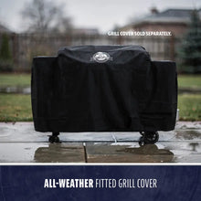 Black all-weather fitted grill cover on wheeled cart.