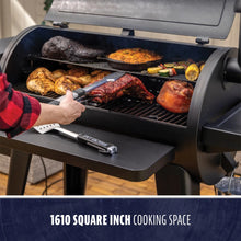 Large black pellet grill with open lid, showing meats and veggies cooking. Features 1610 sq. in. cooking space.