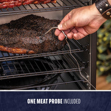 Hand inserting a meat probe into brisket on smoker rack. Text: "One meat probe included." Stainless steel probe visible.