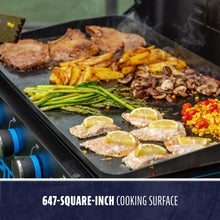 Large flat-top grill with 647-square-inch cooking surface, shown grilling meat, vegetables, and fish with lemon slices.