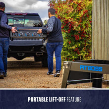 Two people carry a portable Pit Boss grill with lift-off feature, shown near a truck and outdoor setting.