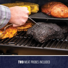 "Grill with two meat probes included, cooking corn and meat."