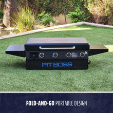 Black Pit Boss fold-and-go portable grill on grass.
