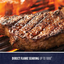 Grilled steak with char marks on a hot grill, showcasing direct flame searing up to 1000°.