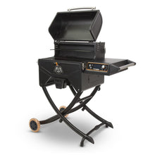 Portable black pellet grill with folding legs, side shelf, control knob, and wheels for easy transport.