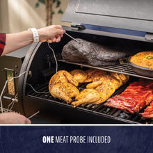 Pellet grill with open lid showing smoked meats and cornbread; one meat probe included for temperature monitoring.