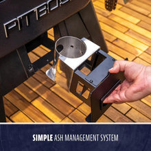 Hand pulling out a stainless steel ash cup from a Pit Boss grill, showing a simple ash management system.
