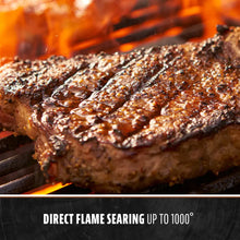 Grilled steak with charred exterior on grill, direct flame searing up to 1000°.